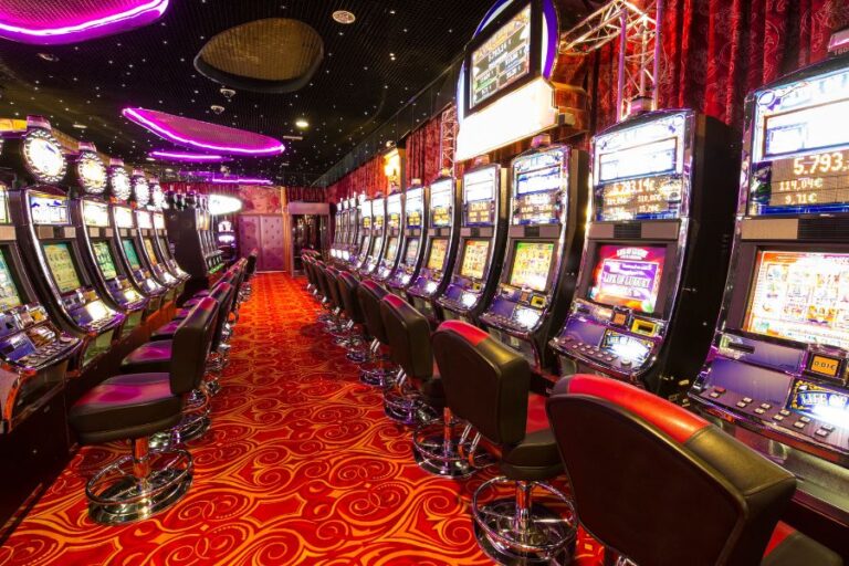 A casino with lots of gambling machinery and red carpet