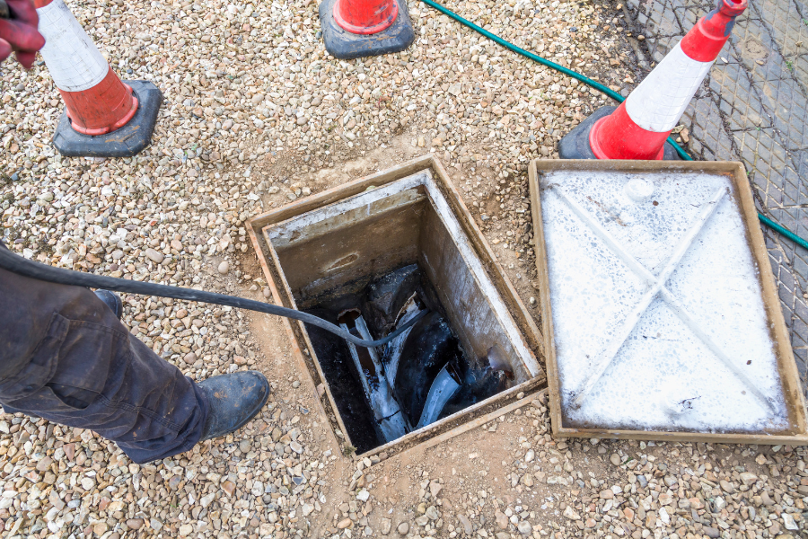 a gravel patio with a drain lid removed
