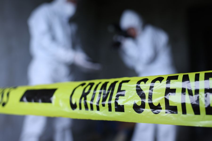 a close up shot of crime scene tape with trauma cleaners in the background