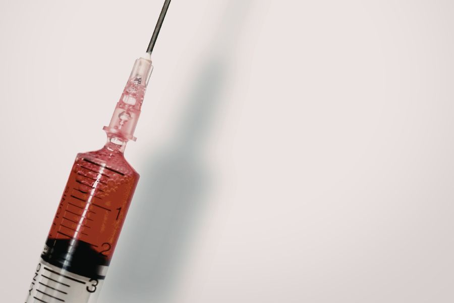 a close up of a needle that has been used and filled with blood