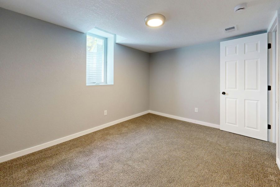 An empty room of a void property with white painted walls and cream carpet