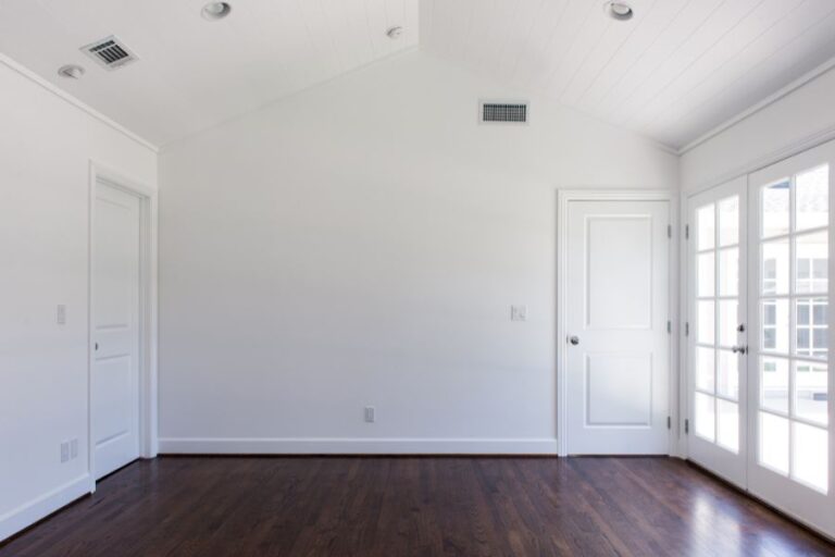 An empty room of a void property with white walls and wooden flooring