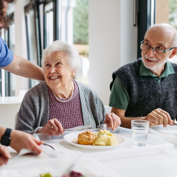 Care home residents dining in a clean and well maintained residential care environment