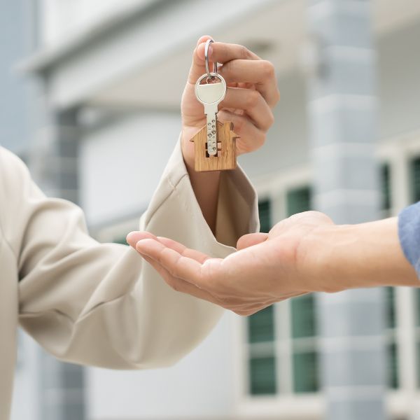 Property handover between landlord or property manager and tenant outside residential building